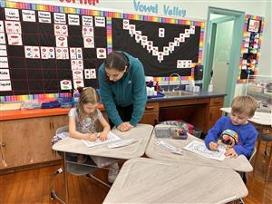 student helps younger students with project